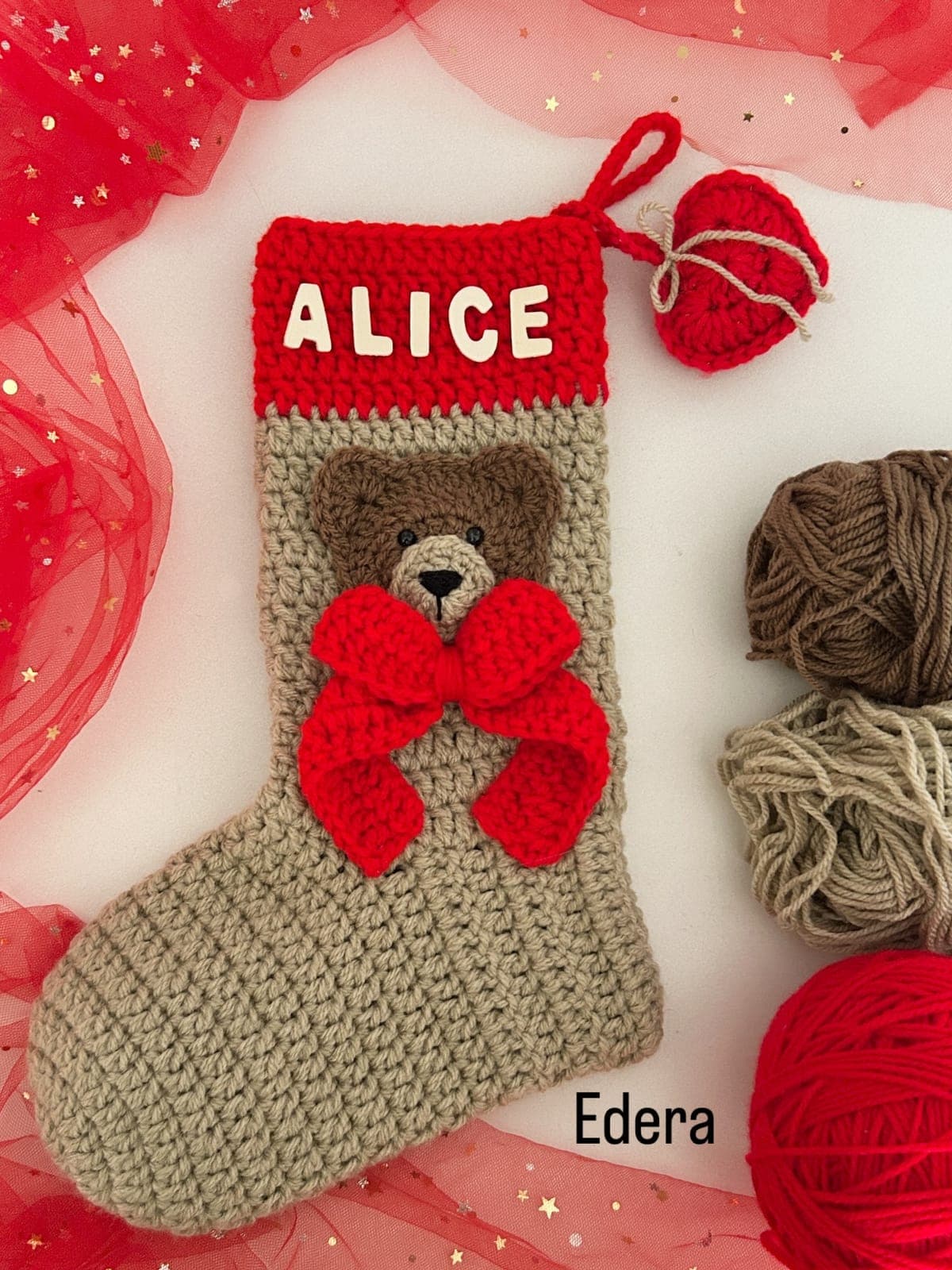 Stocking with the name Alice, a teddy bear and a red crochet bow