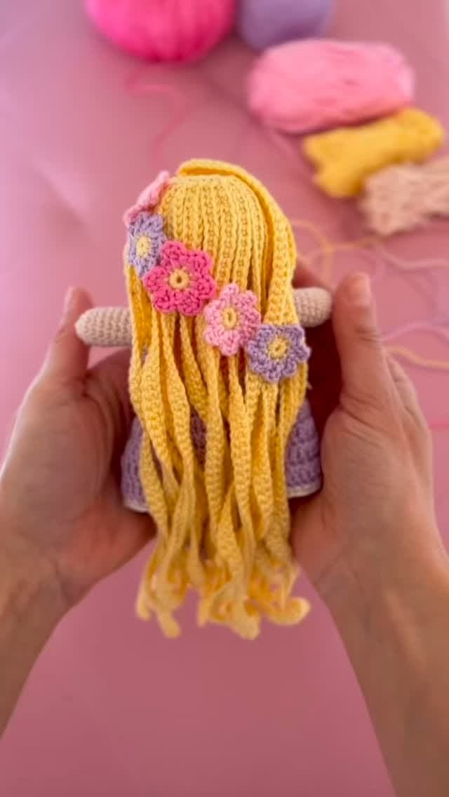 Bambolina amigurumi con lunghi capelli biondi e fiori all'uncinetto